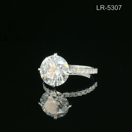 Round Cut Solitaire Diamond Ring with Pavé Band and Classic Prong Setting.