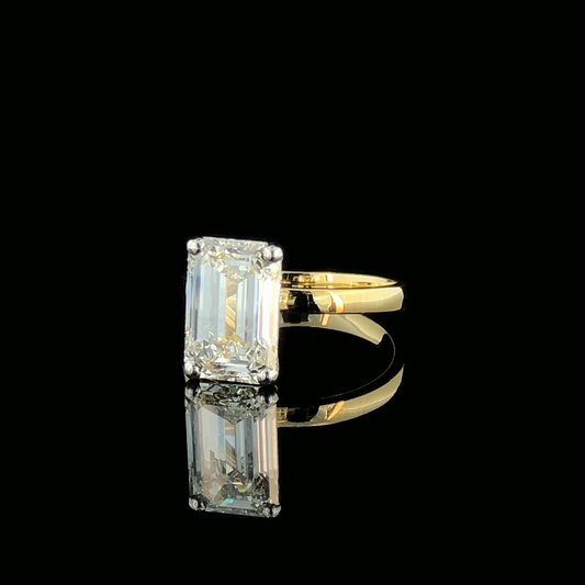 Emerald Cut Solitaire Diamond Ring with Four Prong Setting and Plain Band.